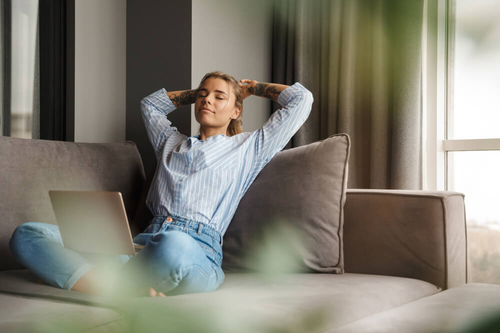 young relaxed woman resting while sitting with laptop